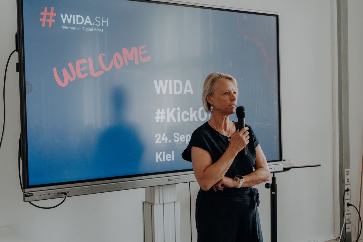 Tenna Dahl spricht mit Mikrofon beim Kick-off des WIDA-Programms in Kiel